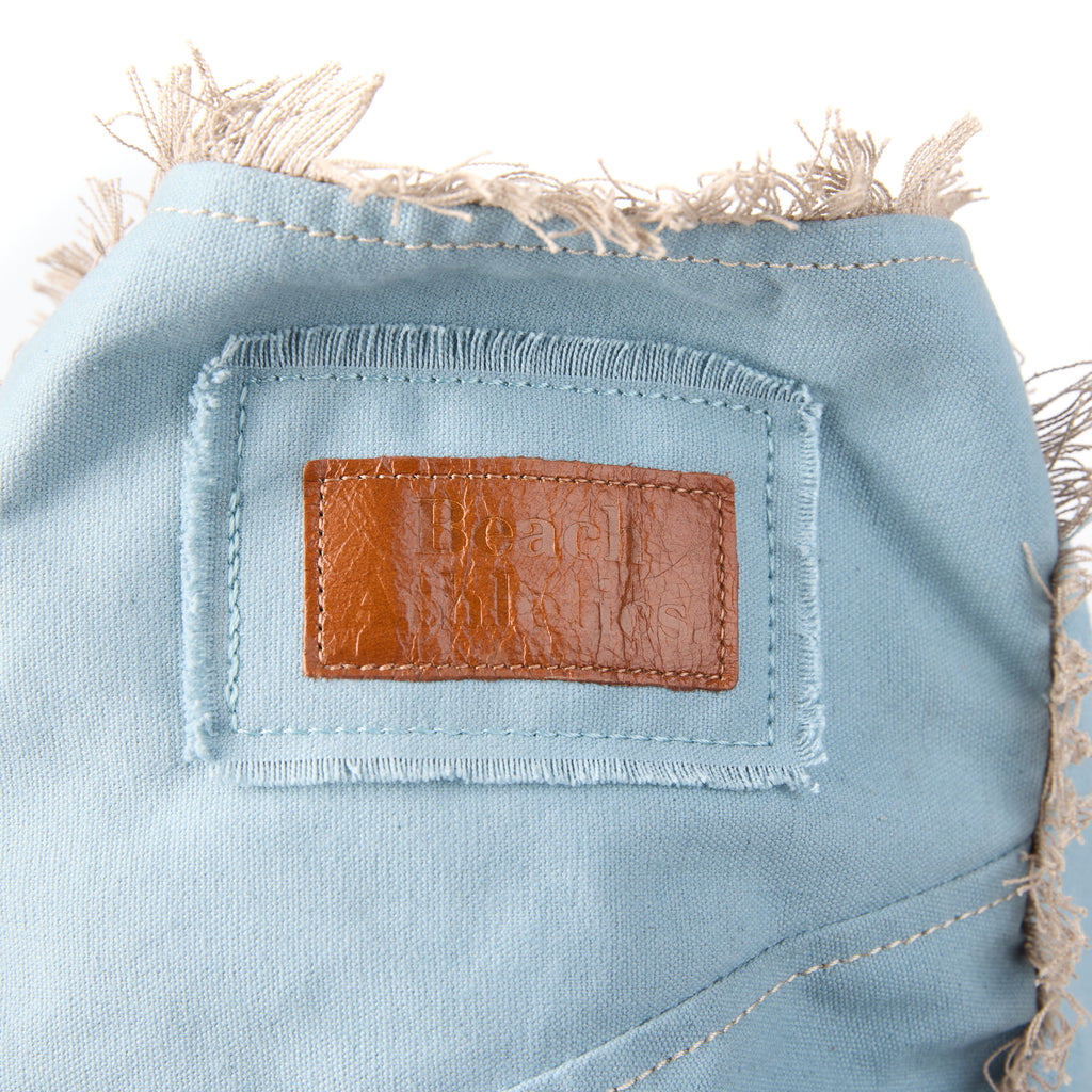 Bonnie bag (a blue washed canvas beach bag), close-up of the branded leather logo patch