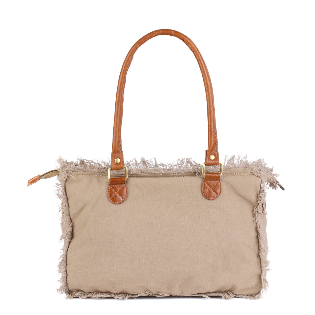 Lani: a beige washed canvas shoulder bag with frayed raw edges, tan leather trim and embroidered Saint-Tropez Pampelonne lettering, back view