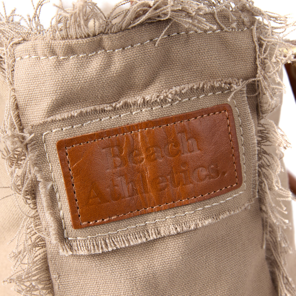Lani bag (a beige washed canvas shoulder bag), close-up of the embroidered Beach Athletics logo patch