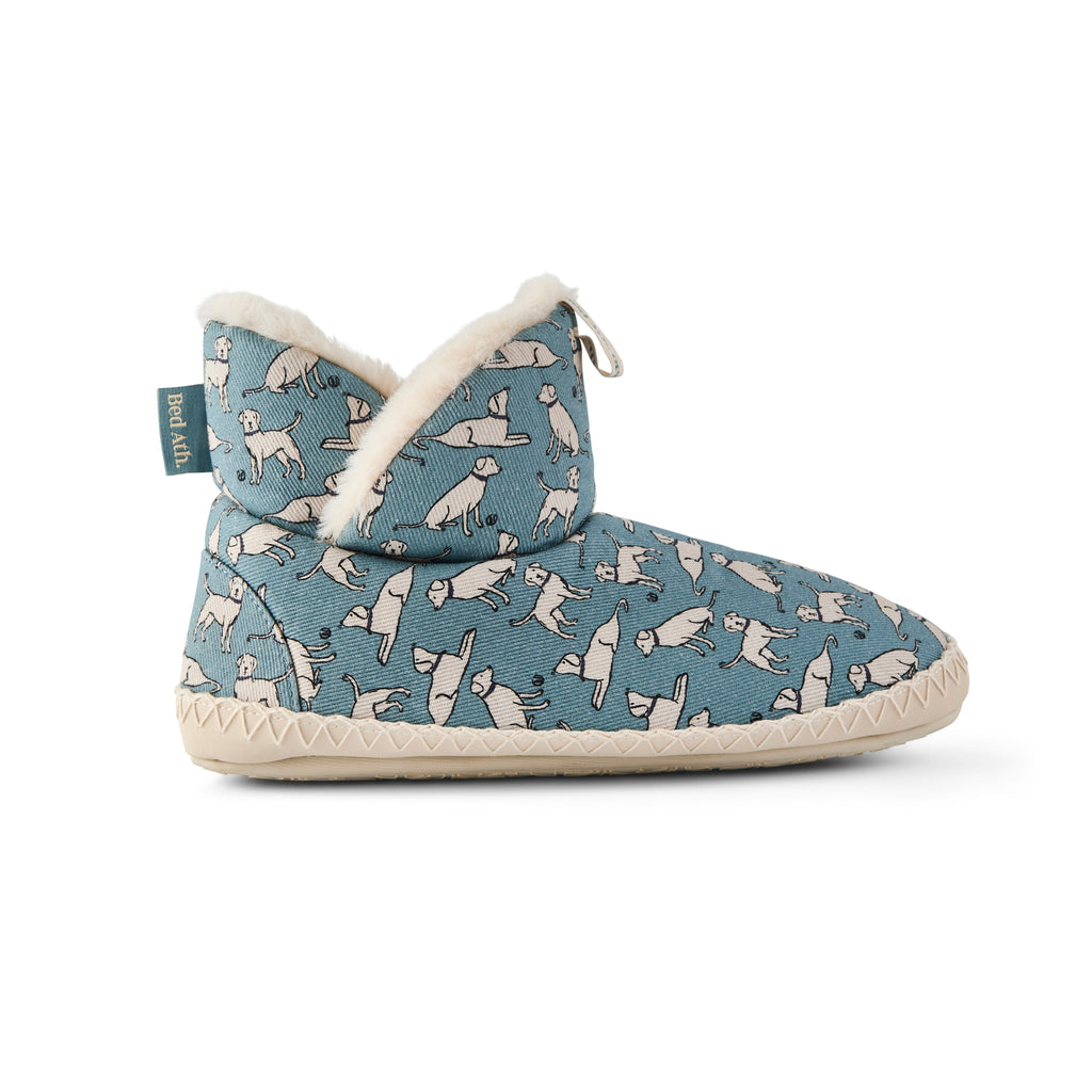 A single slip-on ankle boot for children, featuring a blue fabric upper with a white cat pattern, a soft white faux-fur collar, and a cream-colored sole, shown against a plain white background.