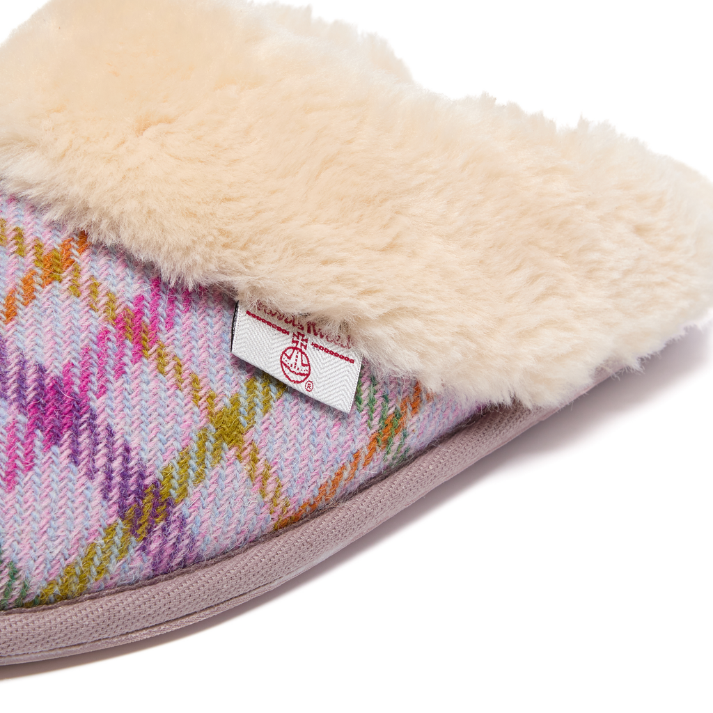 Close-up of a slipper with a Harris Tweed plaid pattern and fluffy texture on a white background