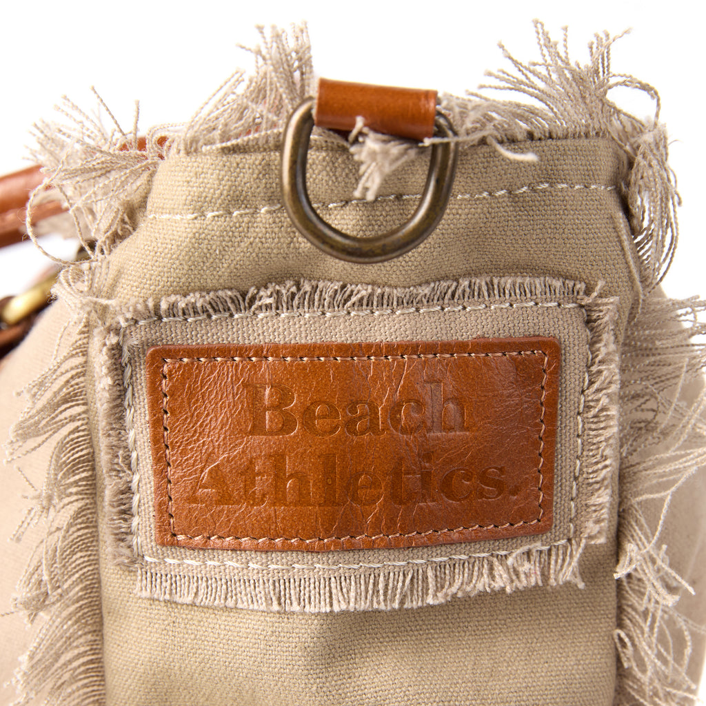 Shauni bag (a beige washed canvas shoulder bag), close-up of the embroidered Beach Athletics logo patch