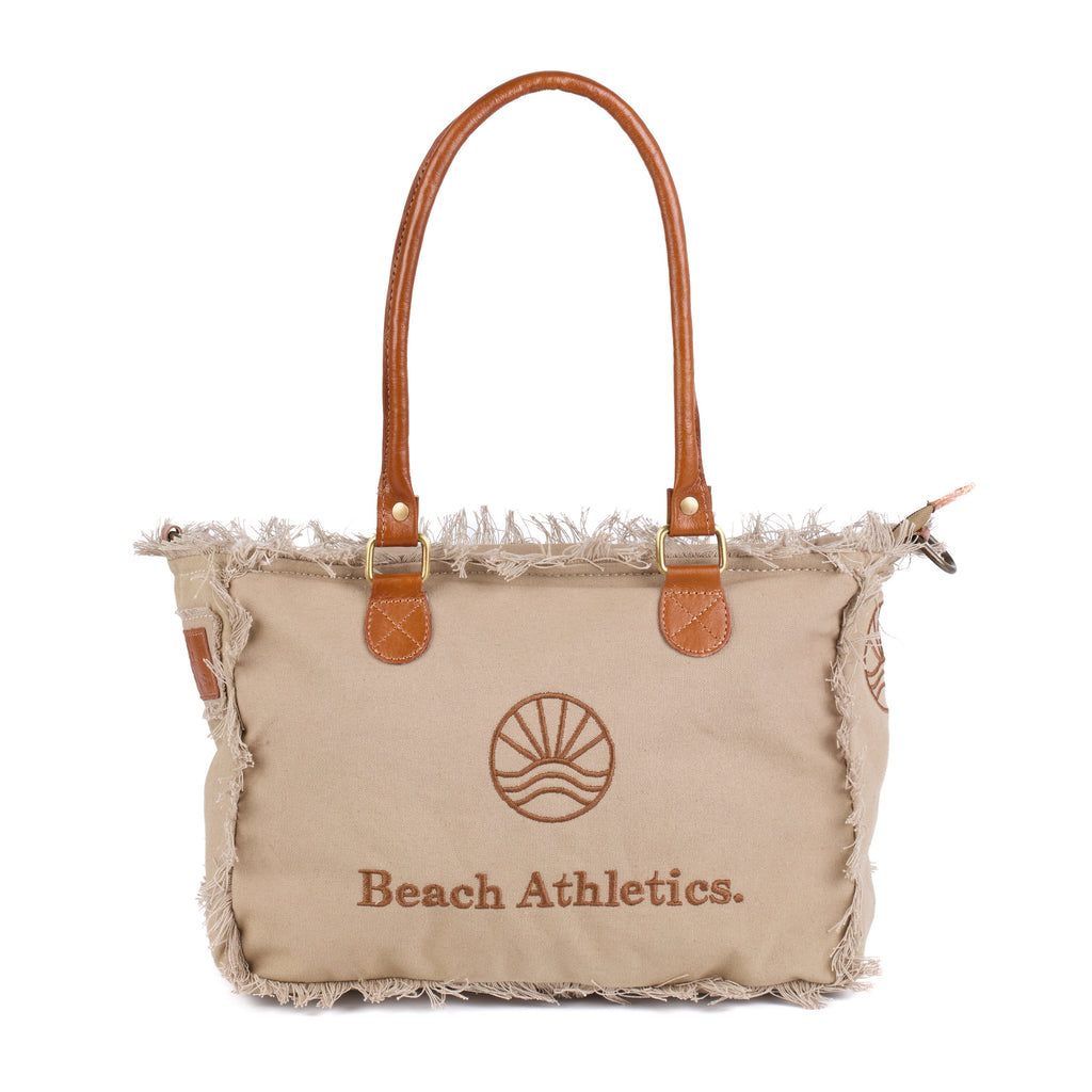 Shauni: a beige washed canvas shoulder bag with frayed raw edges, tan leather trim and an embroidered sunrise Beach Athletics logo, front view with the handles raised