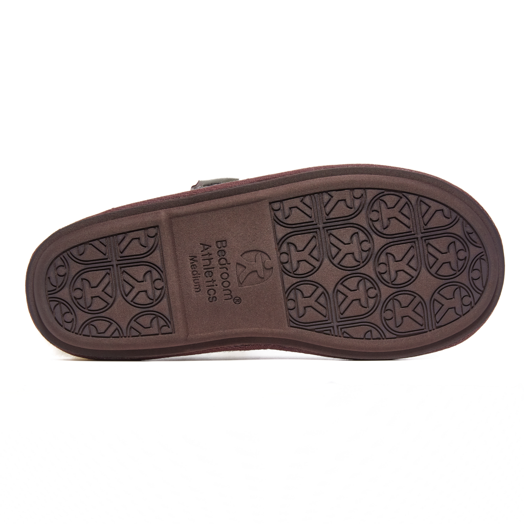 Brown slipper sole with patterned tread and 'Bedroom Athletics' branding on a white background